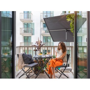 Anthrazitfarbener Doppler Balkonschirm (130x180 cm) mit Handöffner auf einem Balkon.