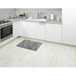 Mehrfarbige Wenko Badematte Sassi (50x80 cm) im Stein-Design vor Küchenzeile.