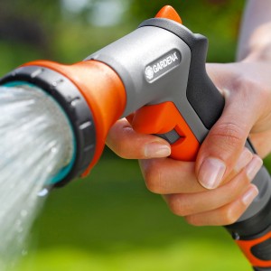 Gardena Gartenbrause Classic Set in Nutzung: Hand hält Brause, Wasserstrahl sichtbar.