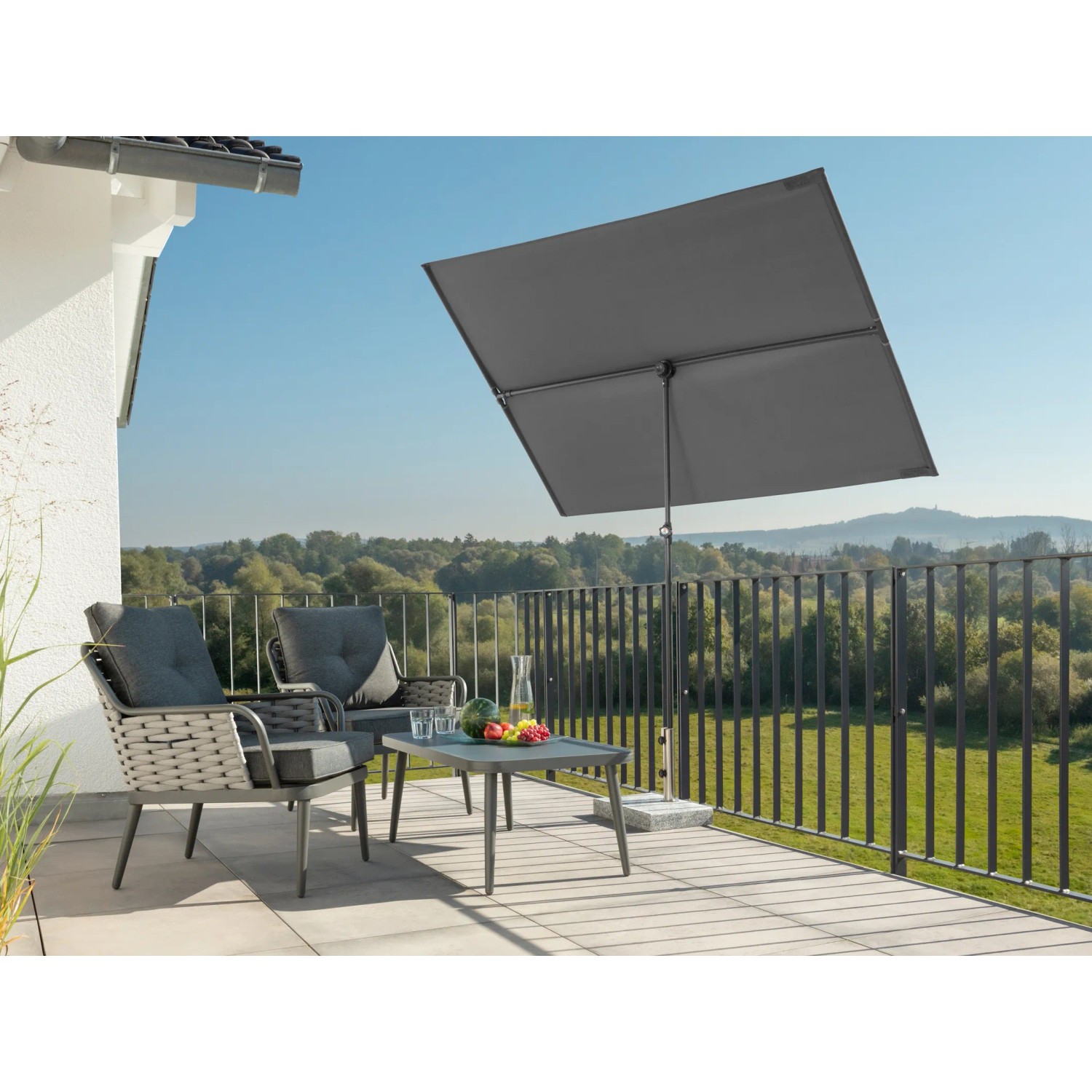 Anthrazitfarbener Schneider Balkonschirm Avellino 130x180 cm auf einem Balkon mit Möbeln.