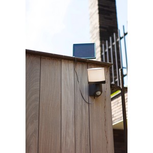 Anthrazitfarbene Lutec LED Solar-Wandleuchte Sunshine mit Bewegungssensor an Holzwand.