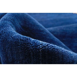 Detailansicht des blauen Wollteppichs Gloria, handgewebt mit dichtem Flor.