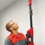 Mann schleift Decke mit Einhell Trockenbauschleifer TC-DW 225. Inkl. Koffer und 6 Schleifscheiben.
