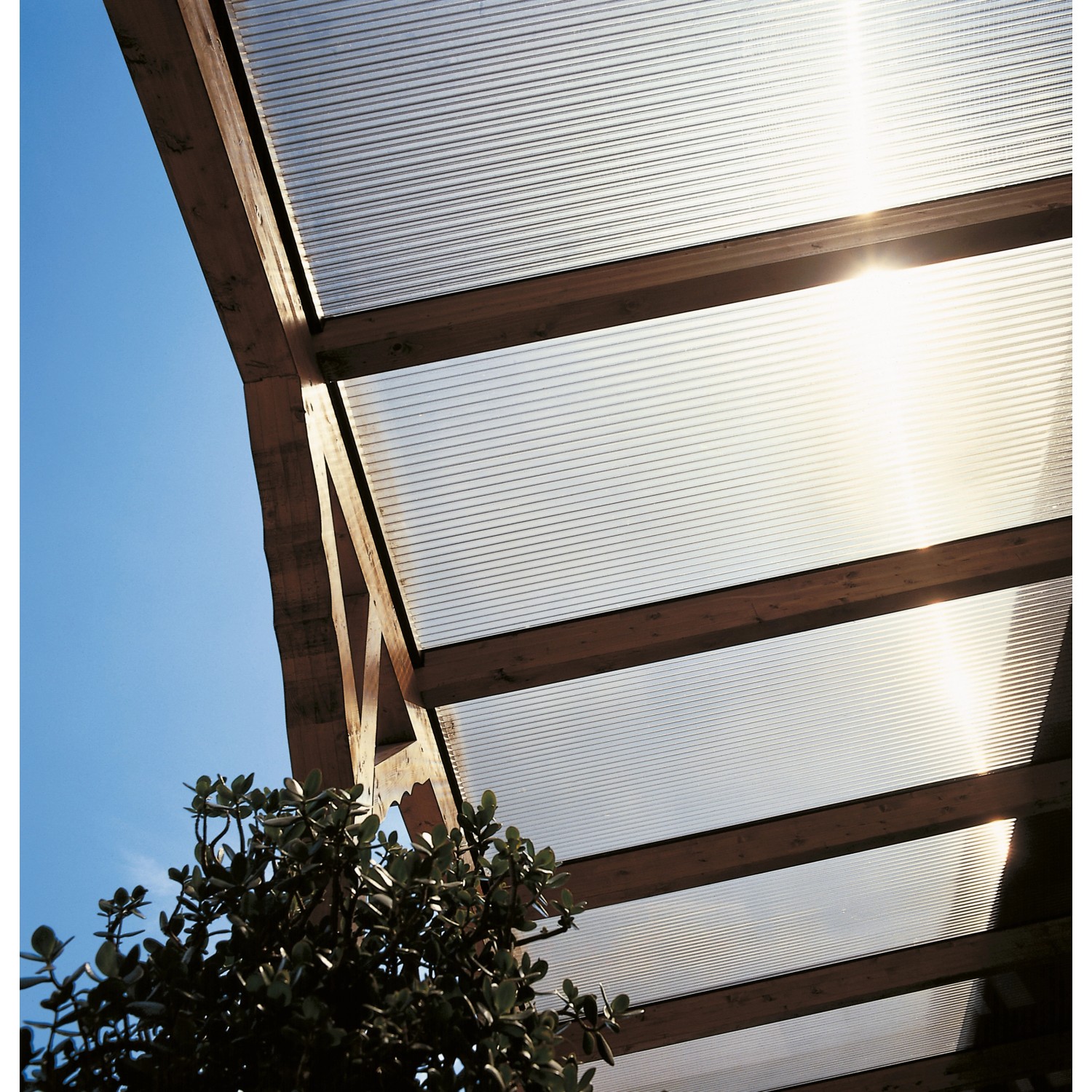 Bronzefarbene Hohlkammerplatte Acryl (16 mm) als Terrassenüberdachung mit Holzkonstruktion.