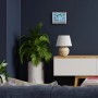 Bresser VentAir H Thermo-Hygrometer in Anthrazit an Wand über Sideboard mit Lampe und Pflanze.