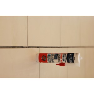CIMSEC Fliesenkleber 4 in 1 Weiß Tube vor Fliesenwand, zum Kleben, Dichten, Füllen und Verfugen.