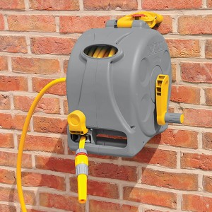 Hozelock Schlauchtrommel Compact Reel 2in1 mit 25m Schlauch an einer Wand.