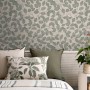 Vliestapete mit grün-grauem Blättermuster im skandinavischen Stil an einer Wand im Schlafzimmer.