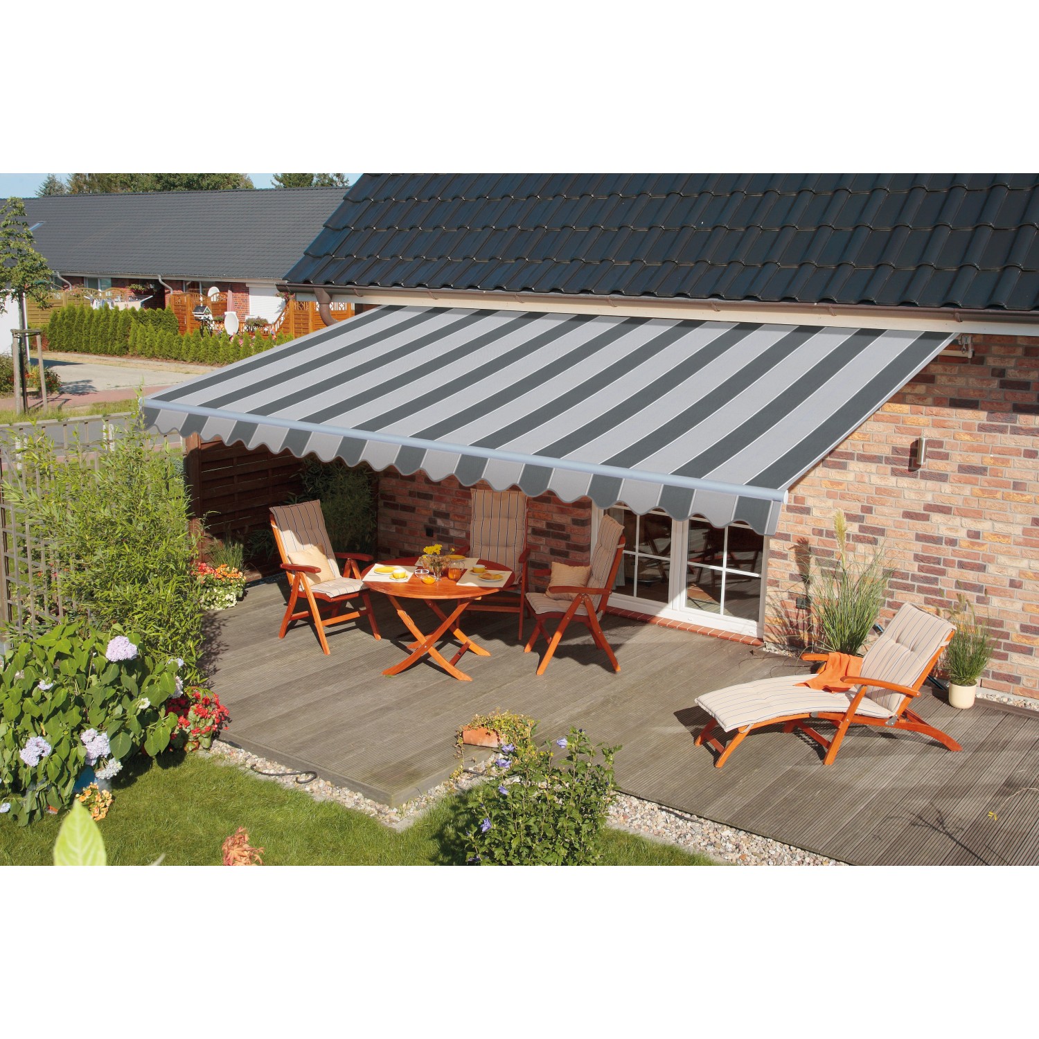 Gestreifte, graue Gelenkarmmarkise Star Fix (300x200 cm) über einer Terrasse mit Gartenmöbeln.
