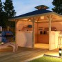 Weka Freizeitlaube Rimini Spar-Set mit Tresen, Barhockern und Liege auf Holzterrasse im Garten.