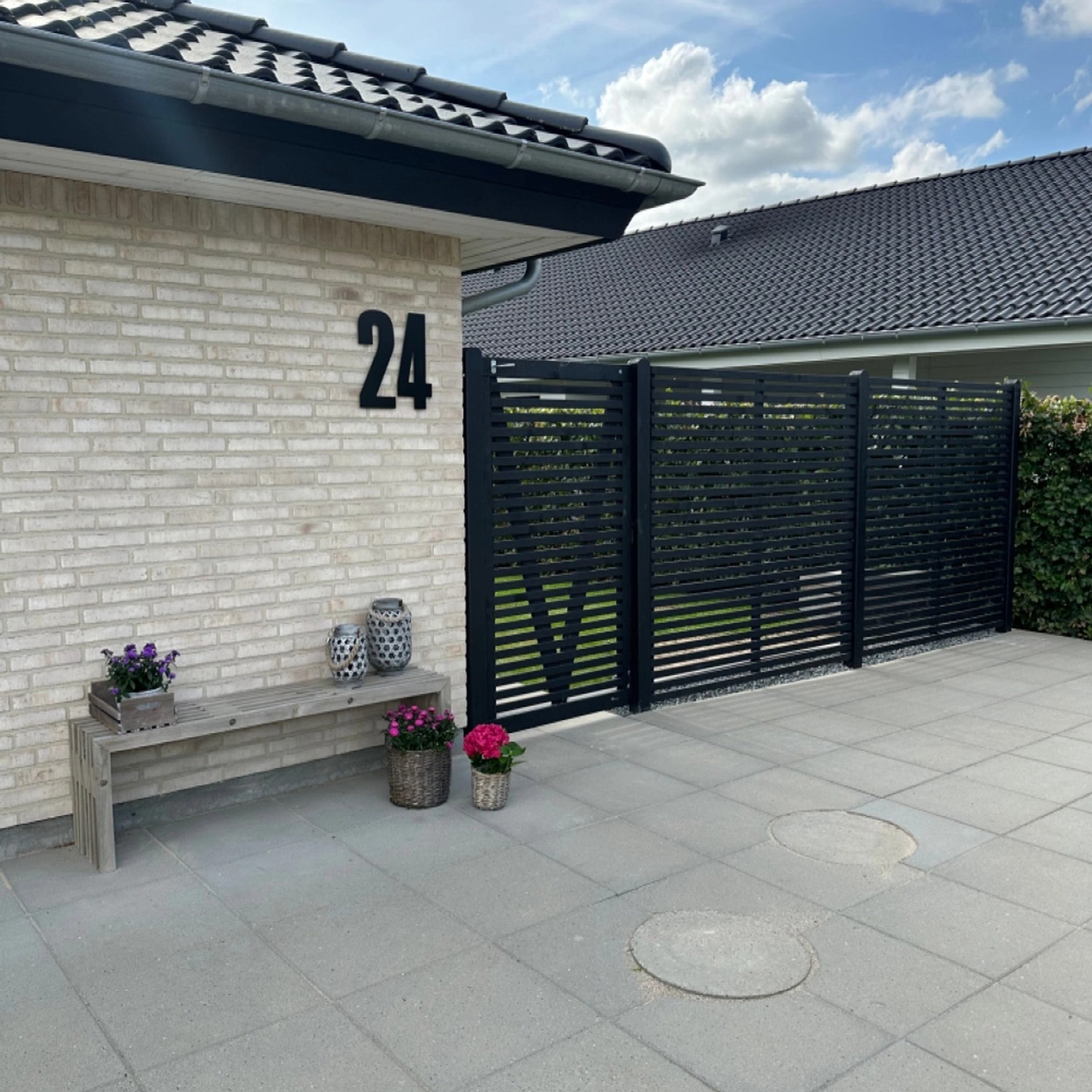 Schwarzer Sichtschutzzaun Tokyo aus Nadelholz, 180x180 cm, im Garten als stilvolle Grundstücksbegrenzung.