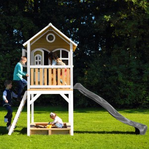 Axi Sarah Spielhaus mit Rutsche, Leiter und Sandkasten. Kinder spielen im braun-weißen Holzhaus.