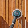 Gardena Akku-Multi-Reiniger AquaBrush im Einsatz an einem Holzzaun.
