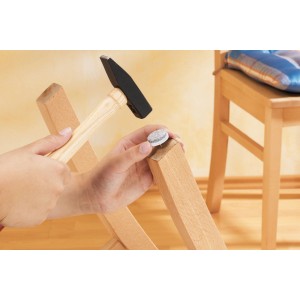 Filzgleiter werden mit Hammer an einem Stuhlbein befestigt.