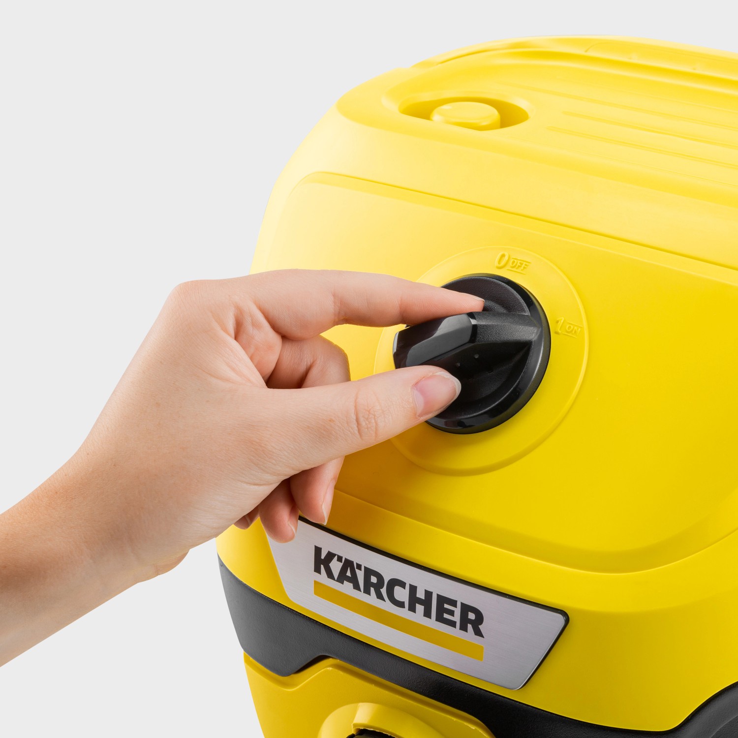 Detailaufnahme: Hand schaltet gelben Kärcher Akku Nass-Trockensauger WD 2-18 ein.