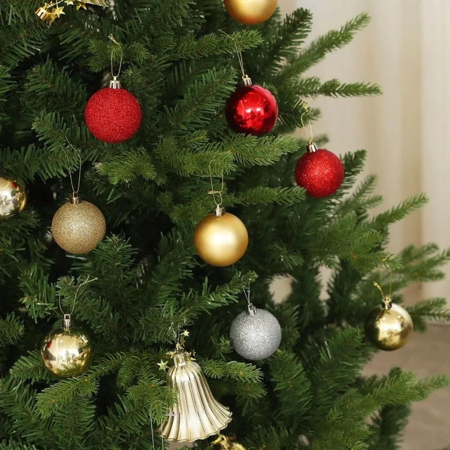 Grüner künstlicher HOMCOM Weihnachtsbaum, geschmückt mit roten, goldenen und silbernen Kugeln und einer Glocke.