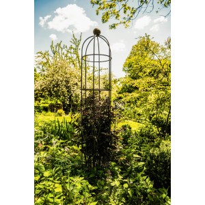 Eleo Obelisk Messina klein, feuerverzinkt, im Garten mit Pflanzen bewachsen.