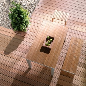 Terrasse mit Osmo Bangkirai Terrassendielen, Tisch und Bank aus Holz, Topfpflanze.