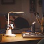 Weiße Philips LED Schreibtischleuchte Bucket mit Handy im Stifthalter auf einem Schreibtisch.