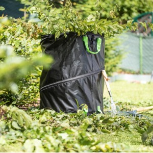 Schwarzer PopUp Gartensack Long-Life (170 l) mit Gartenabfällen und Laubrechen im Garten.
