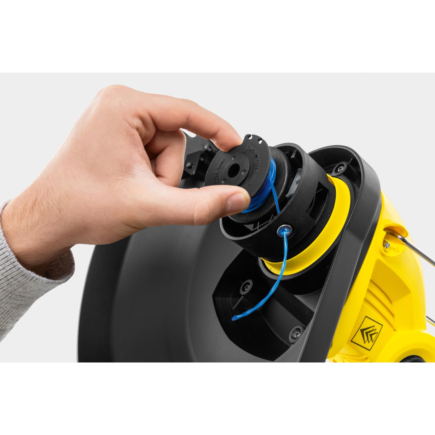 Detailaufnahme: Hand wechselt Spule am Kärcher Akku-Rasentrimmer LTR 18-30 Battery.