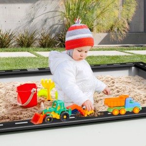 Sandkasten mit Rennbahn Sunny Sandy: Kind spielt mit Spielzeugautos und Sandspielzeug im Sandkasten.
