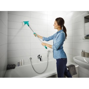 Frau reinigt Fliesen mit Leifheit Fliesen- & Wannenwischer Flexipad mit Teleskopstiel im Badezimmer.