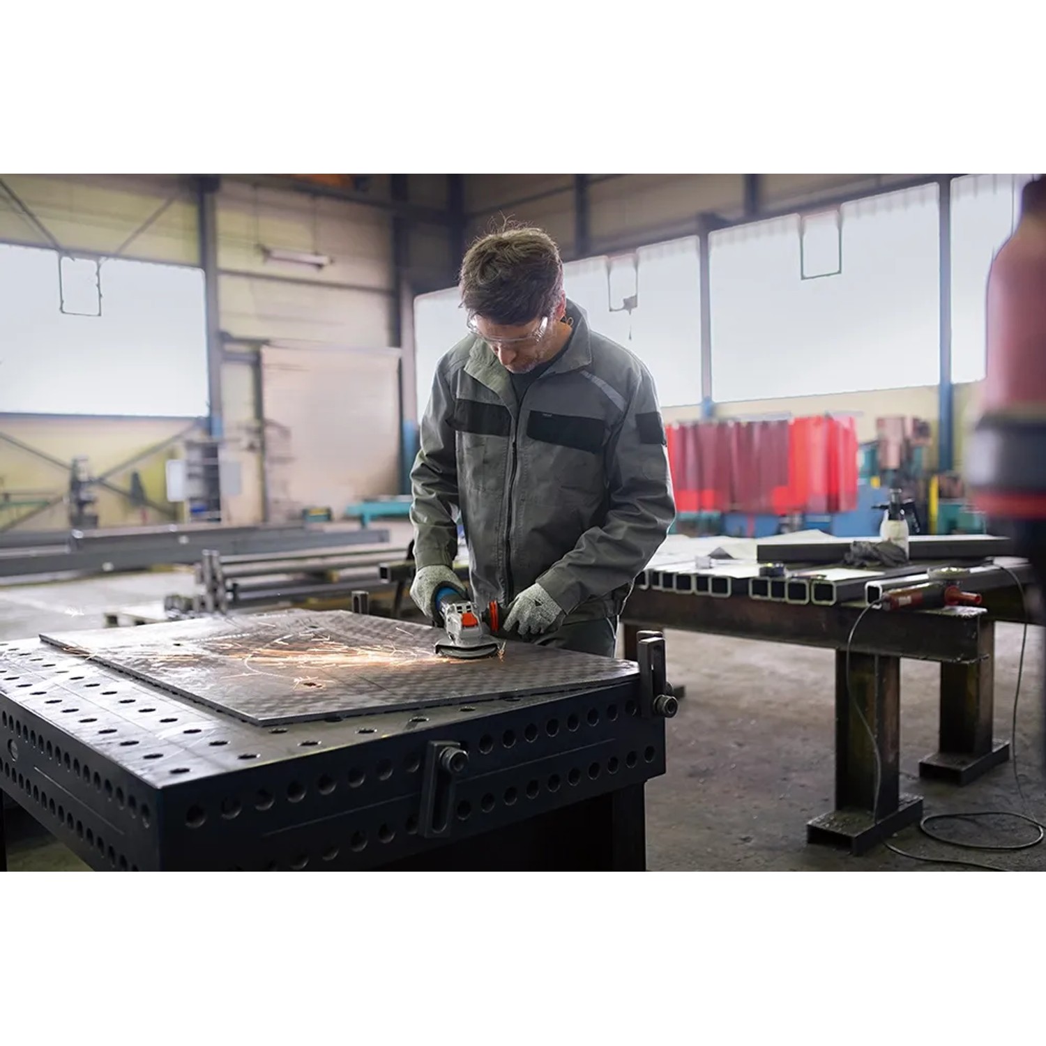 Anwender schleift Metall mit Bosch Professional GWX 14-125 S X-Lock Winkelschleifer.