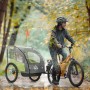 HOMCOM Regenschutz für Kinderfahrradanhänger, transparent, schützt vor Regen. Ein Radfahrer mit Anhänger im Herbstwald.