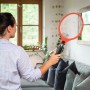 Frau benutzt elektrische Fliegenklatsche Akku comf. im Wohnzimmer.