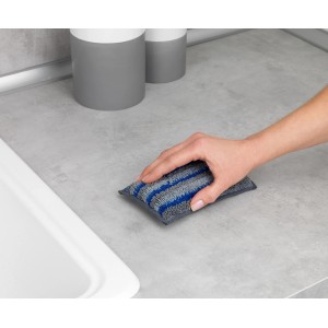 Hand wischt mit blau-grauem Wenko Mikrofaser Spülschwamm Miko eine Küchenoberfläche sauber.