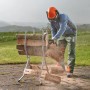 Wolfcraft Sägebock SB 60 klappbar mit Mann beim Sägen von Holzscheiten im Garten.