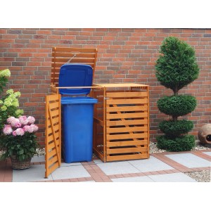 Honigbraune Mülltonnenbox Vario V für 2 Tonnen aus Kiefernholz mit geöffneter Tür und blauer Tonne.