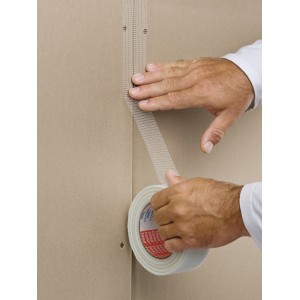 Anwendung von Tesa Glasfaser-Gewebeband (weiß, 25 m x 5 cm) zur Reparatur einer Wand.