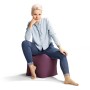 Frau sitzt auf einem auberginefarbenen Sitting Point Hocker (60 l).