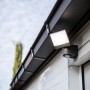 Lutec LED-Außenstrahler Sunshine mit schwenkbarem Kopf, montiert an einer Hauswand.