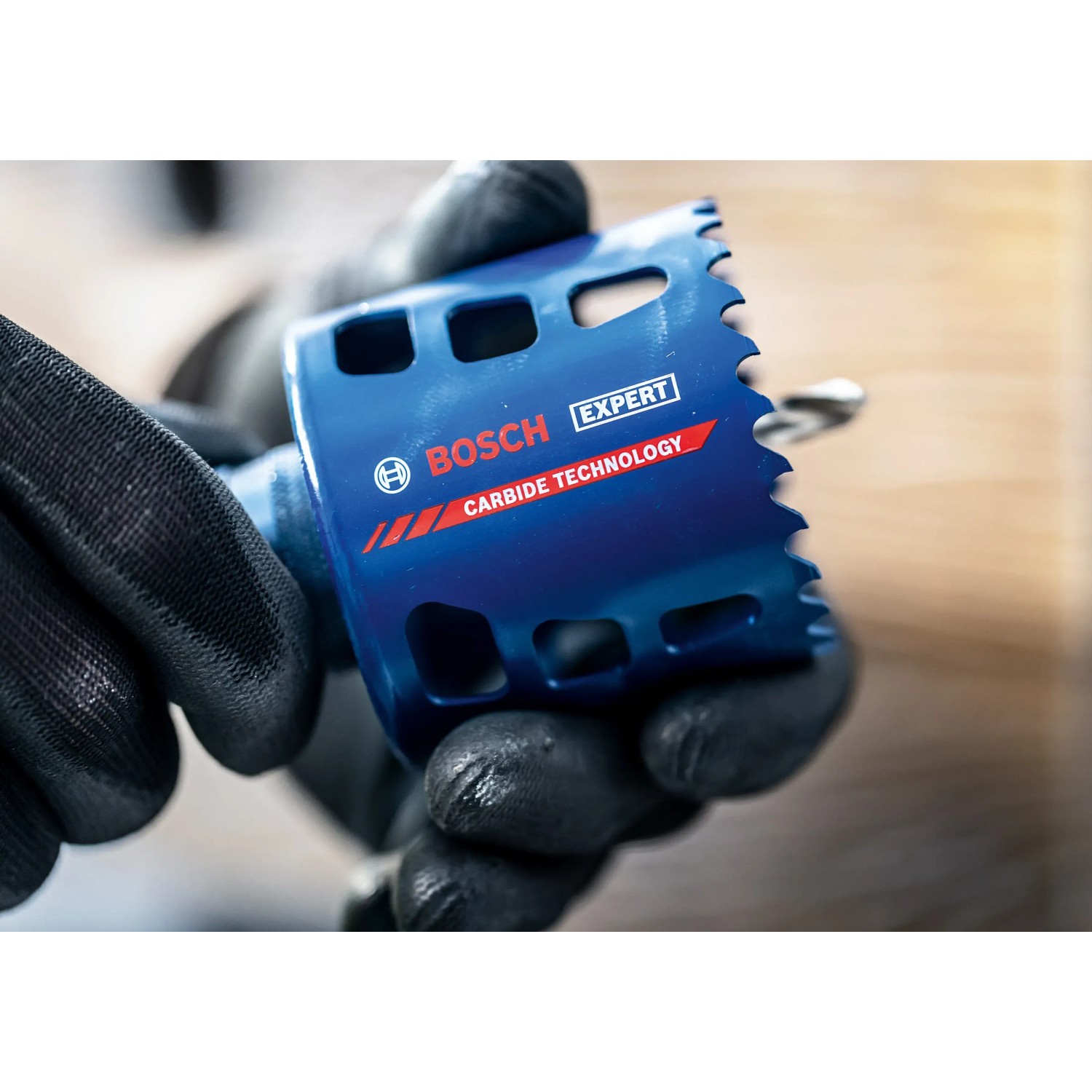 Blaue Bosch Expert Lochsäge (Ø 51 mm) für robuste Materialien in Hand mit Arbeitshandschuhen.