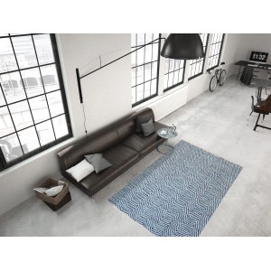 Blauer Wollteppich Melrose (80x150 cm) mit Streifenmuster im Wohnzimmer.