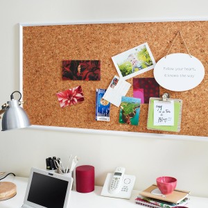 Dekorative, braune Korkplatte (100x50x0,6 cm) an einer Wand mit Fotos und Notizen.