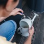Frau befüllt Gießkanne mit Geka Regentonnenanschluss 24,66 mm (3/4) aus Messing.