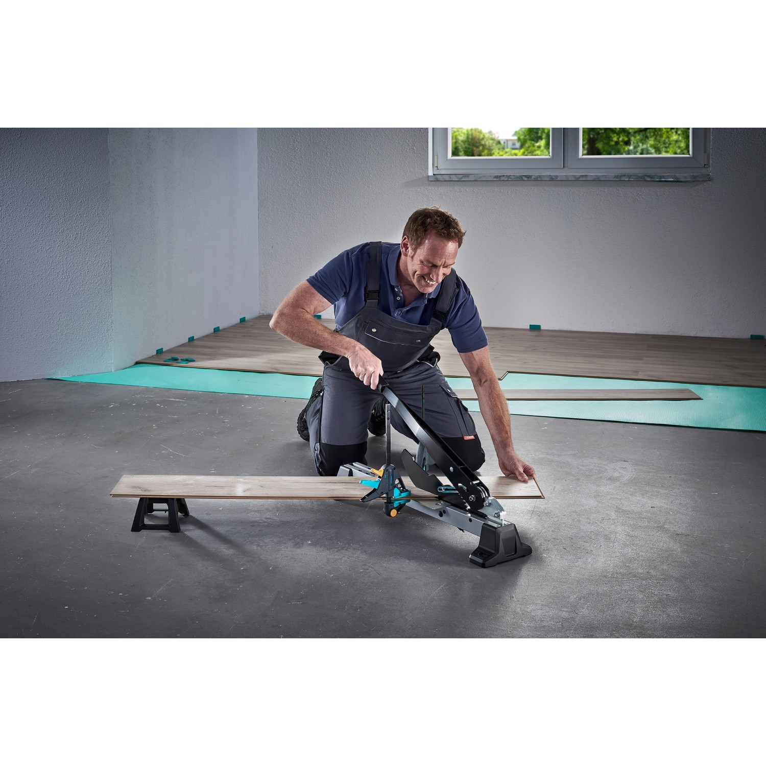 Mann schneidet Laminat mit dem wolfcraft Vinyl- und Laminatschneider VLC 1000. Werkzeug für Laminat und Parkett.