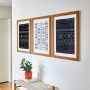 Drei gerahmte Bilder mit Mustern an der Wand, befestigt mit Command Bilder-Montage-Strips.