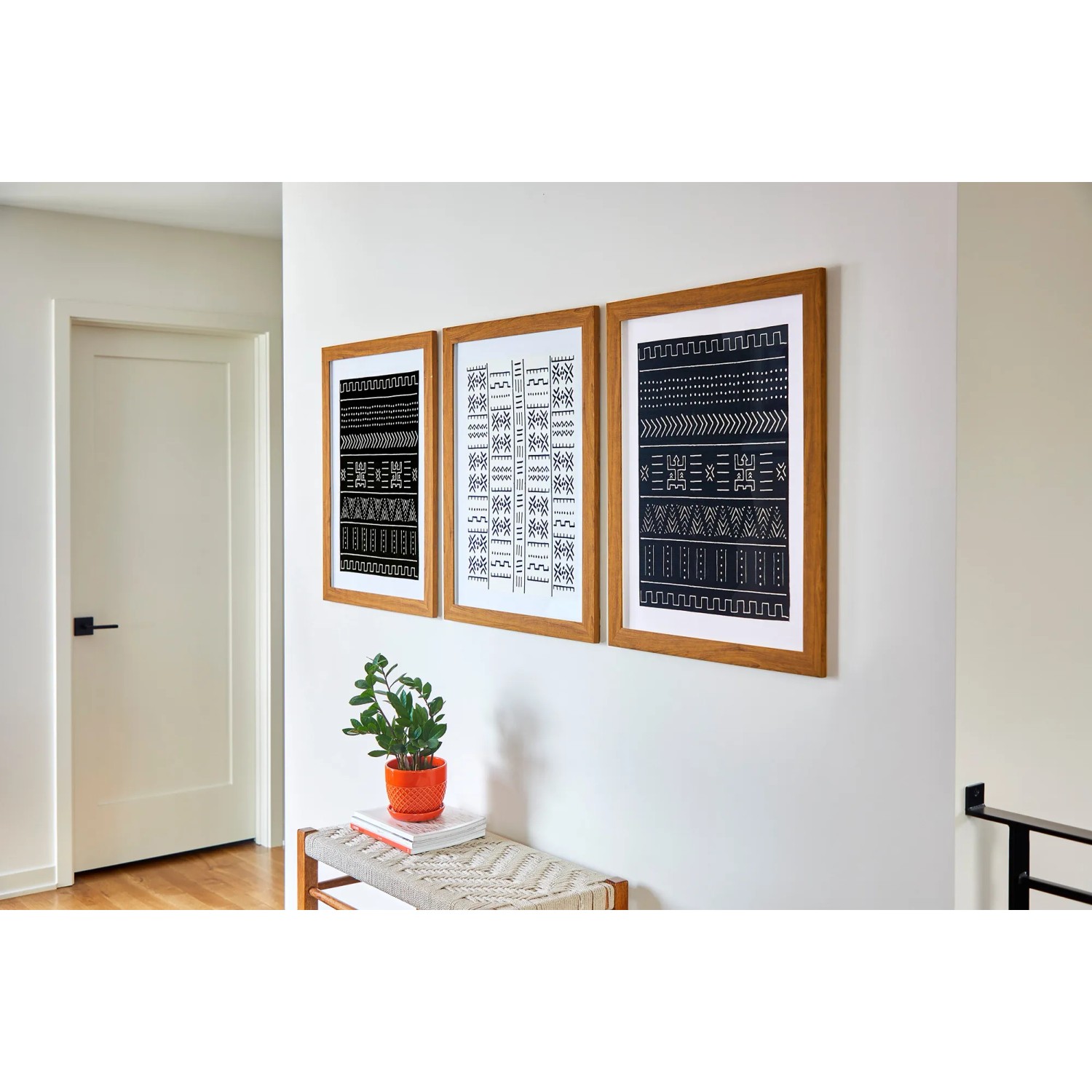 Drei gerahmte Bilder mit Mustern an der Wand, befestigt mit Command Bilder-Montage-Strips.