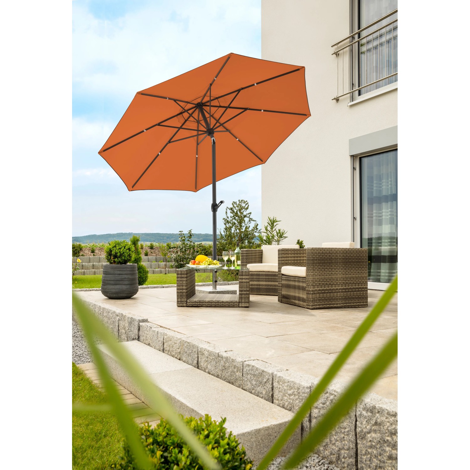 Terracottafarbener Schneider Marktschirm Adria Ø 300 cm mit Knickfunktion auf Terrasse.