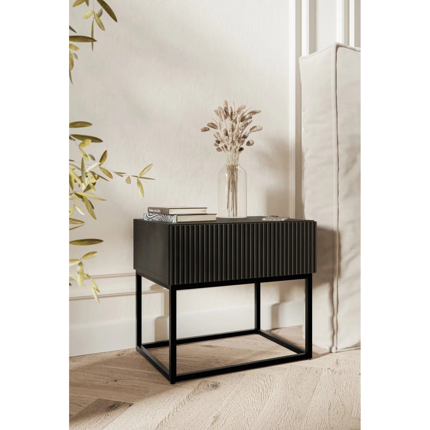 Schwarzer Nachttisch Selsey Veldio mit Rillenfront und schwarzem Metallgestell im Schlafzimmer.