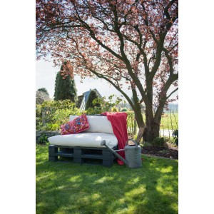 Anthrazitfarbene Osmo Möbelpalette aus Nadelholz mit Kissen und Decke im Garten.