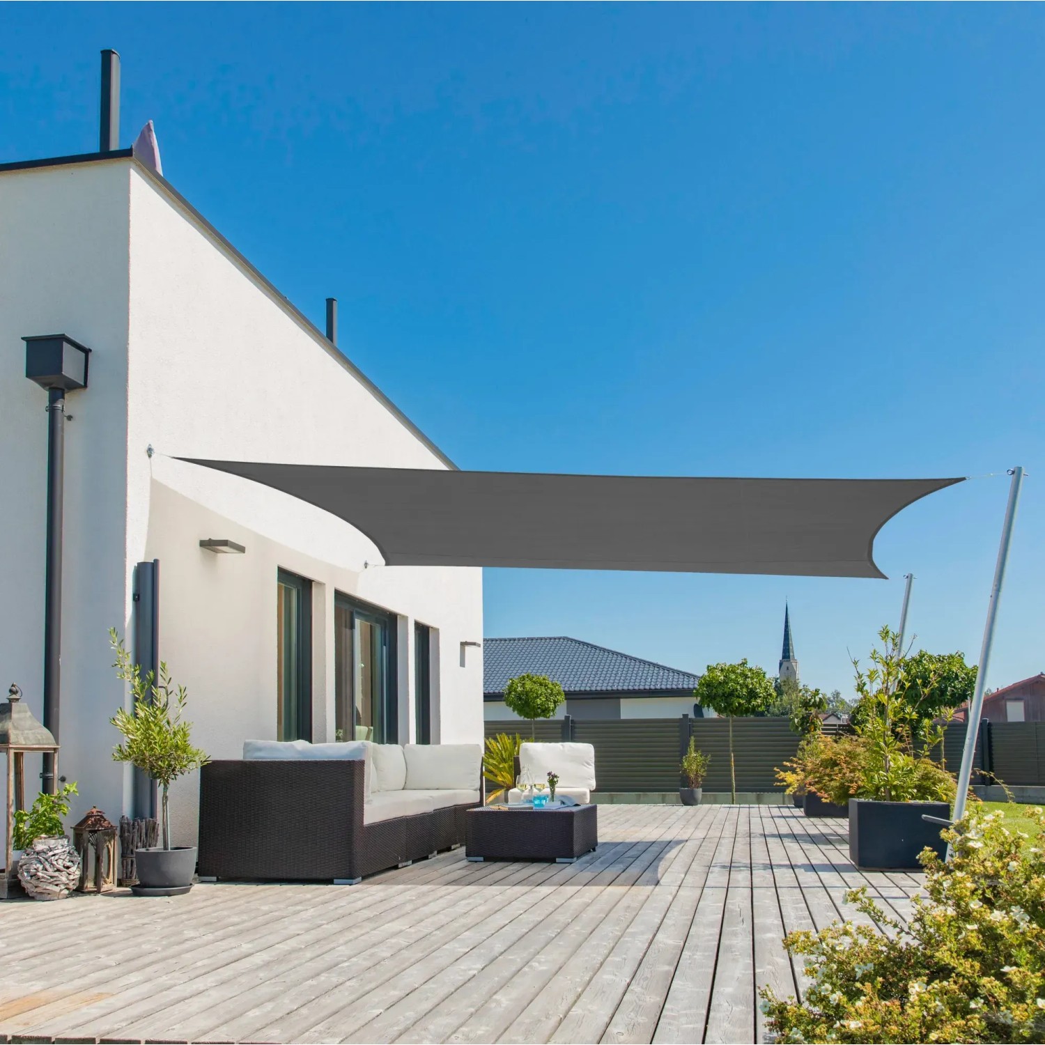 Anthrazitfarbenes Sonnensegel Cannes RE 3 x 4 m über einer Terrasse mit Gartenmöbeln.