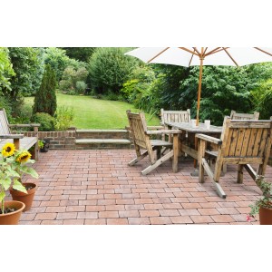 Verlegte Pflastersteine Modern Antik Muschelkalk-Schattiert auf einer Terrasse mit Gartenmöbeln.