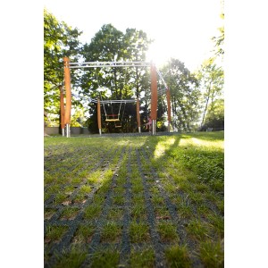 Grüne Rasengitter-Fallschutzplatten 100x100 cm auf Spielplatz mit Schaukel.