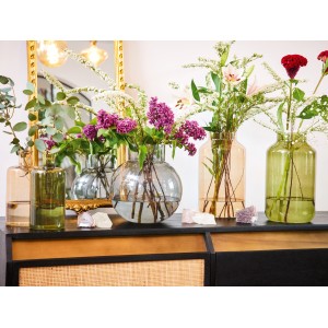Grüne Glas Vase (22,25 cm) mit Blumen auf einem Sideboard. Dekorative Blumenvase für den Innenbereich.